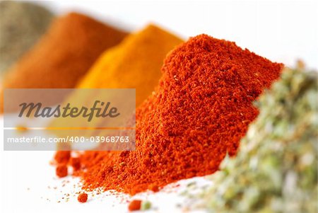 Heaps of various ground spices on white background