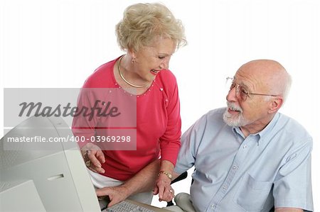 An attractive retired couple surfing the net together. Isolated