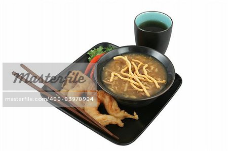 A bowl of Chinese hot & sour soup with crunchy noodles and golden fried fantail shrimp served with tea.  Clipping path included.