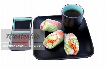 A Japanese salad roll served with tea, and chili & soy sauces for dipping.  Clipping paths included.  (texture of plate and cup may resemble artifacts)