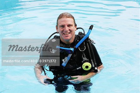 Happy scuba diver in the swimming pool.