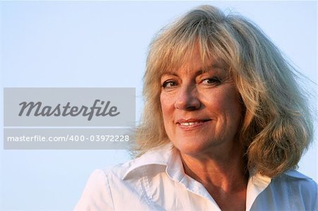 A beautiful, mature woman smiling confidently into the late afternoon sun.