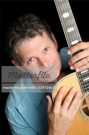 A handsome, experienced middle-aged musician with his beloved guitar.