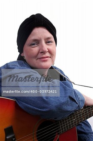 A beautiful woman, bald from health challenges, posing with her guitar.