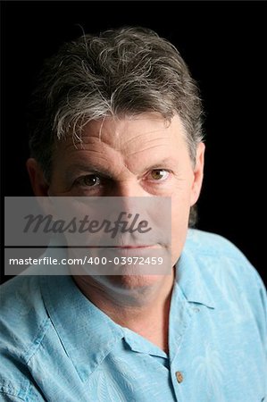 A middle-aged man suffering from depression. Dramatic lighting over black background.