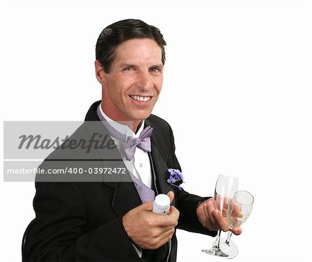 Un bel homme dans un smoking avec une bouteille de champagne et deux verres.