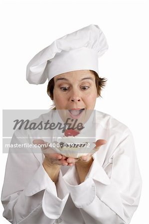 A pastry chef excited about a strawberry cheesecake tart she has just made.  Isolated on white.