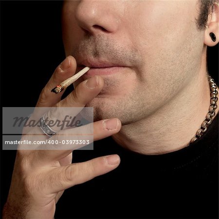 A man smoking a marijuana joint.