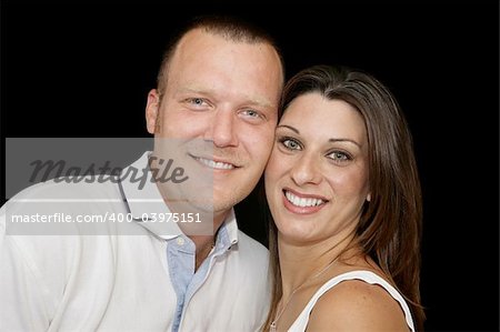 Closeup portrait of a young married couple over black background.
