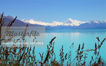 Beautiful mountain turquoise color lake, blue sky and snow peaks reflecting in the water. Lake Tekapo, Mount Cook National Park, New Zealand