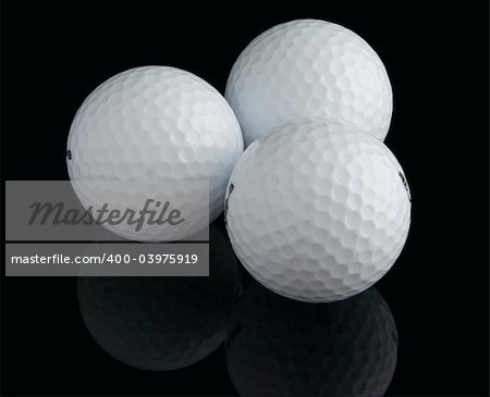 Three golf balls on the black background