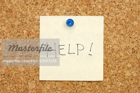 Yellow post-it note asking for help on corkboard