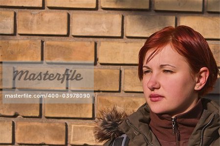 Portrait of a redheaded teen girl against a wall.Shot with Canon 70-200mm f/2.8L IS USM