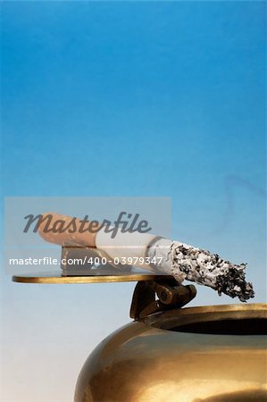 Stub of a cigarette on a bronze ashtray