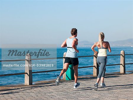 Young couple running by sea