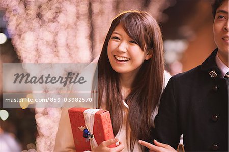 Japanese Couple Holding Hands And Walking Outdoors