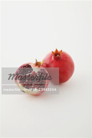 Whole And Half Sliced Pomegranate On White Background Whole And Half Sliced Pomegranate On White Background