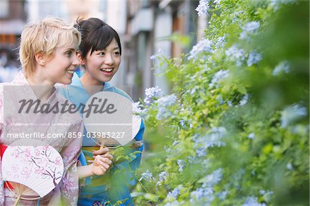 Zwei junge Frauen tragen Yukata Blume Pflanzen suchen