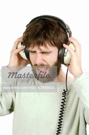 A man not enjoying what he is hearing, listening to music on large retro headphones.  Isolated on white with clipping path.