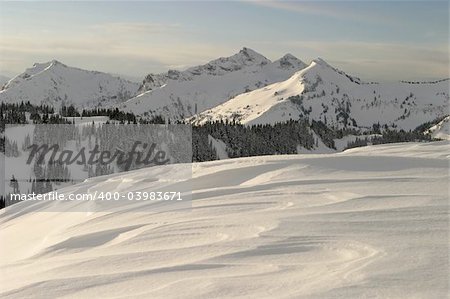 A late winter scene from about 6,000 feet (1,800 meters) up on Mt. Rainier that shows some of the surrounding peaks from the Cascade mountain range. This image was shot on a peaceful dawn with clear sunny skies; a rare day in winter on the mountain.