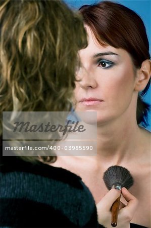 Makeup artist preparing a model for a shoot