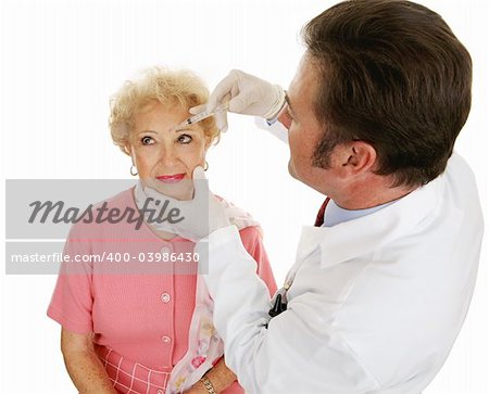 Senior woman having cosmetic injections to fill in wrinkles.  Isolated on white.