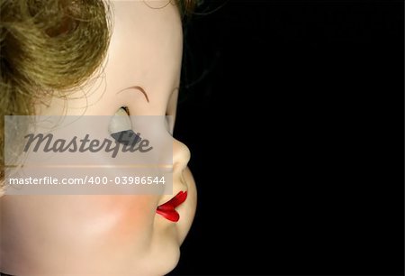 A close up of an antique doll with her eyes closed