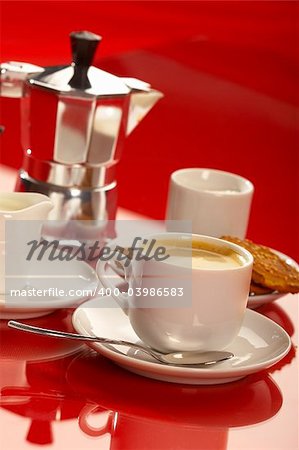 small cup of coffee with coffee pot ober red background