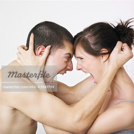 Young couple locked in angry embrace