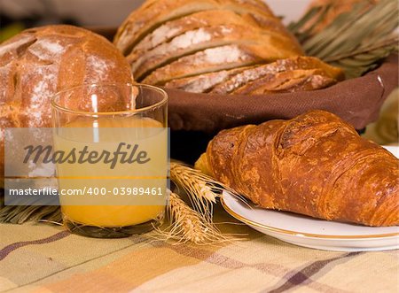 Rustic various baked bread with orange juice