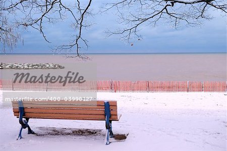 Winter park with a bench covered with snow. Beach area, Toronto, Canada.