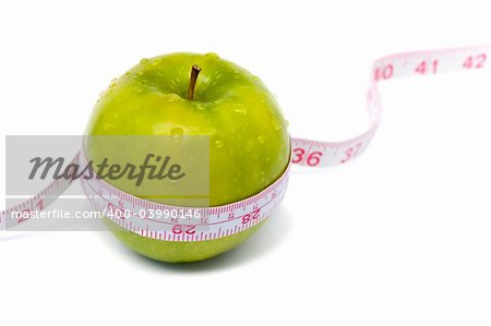 Green apple with measuring tape and water drops. Weight loss series.