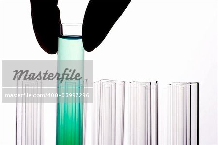 A hand holding a test tube in plain background.