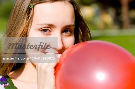 Young woman inflating red balloon