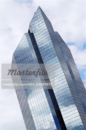 Corporate building with glass walls reflecting clouds