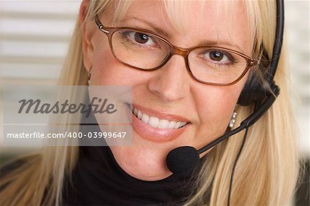 Attractive businesswoman talks on her phone headset.