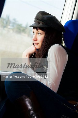 nice girl sitting on a train and looking out of the window