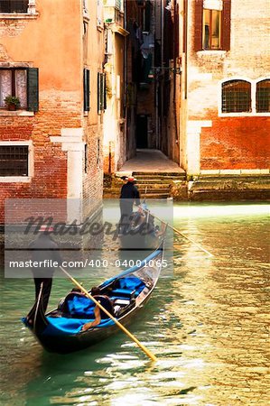 tourist attractions: Venice at the sunset. The focus is on the left wall while Gondolas are slightly blurred