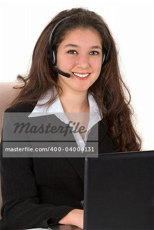 Beautiful professionally dressed young businesswoman with her headset and computer