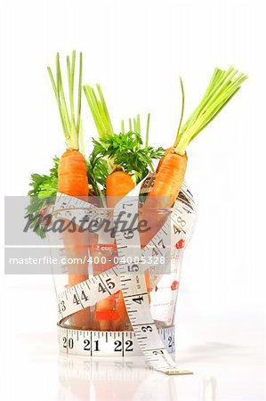 Karotten in ein Messbecher mit Maßband auf weißem Hintergrund