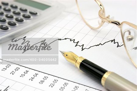 Stock chart with calculator, fountain pen and eyeglasses