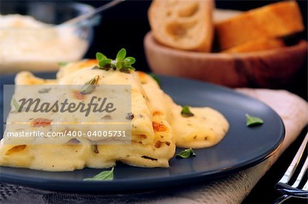 Pâtes de cannelloni au fromage servis sur une plaque avec sauce alfredo