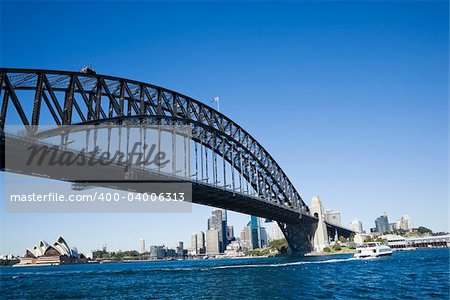 Sydney Harbour Bridge with view of downtown buildings and Sydney Opera House in Australia.