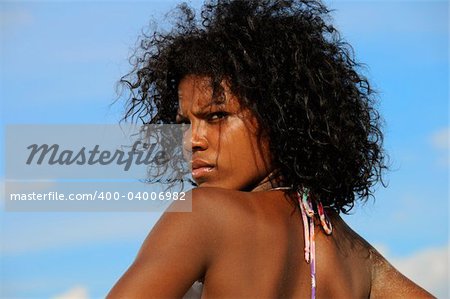 Young model wearing bikini against tropical sky