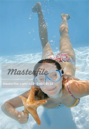 Pretty girl underwater with mask and starfish