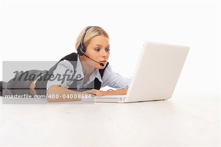 Businesswoman working on her laptop while lying down on the floor