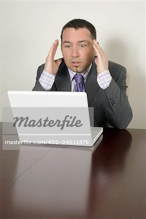 Shocked businessman in his thirties looking at a bad thing on his laptop.