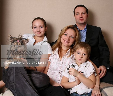 Mum, daddy, two children and yorkshire terrier on a sofa