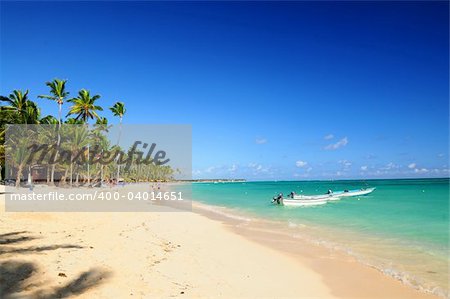 Sandy beach on Caribbean resort and fishing boats at sea