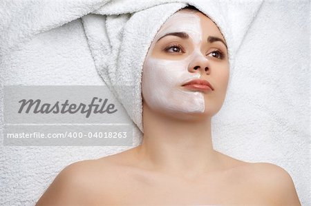 young pretty woman getting facial mask, lot of copyspace